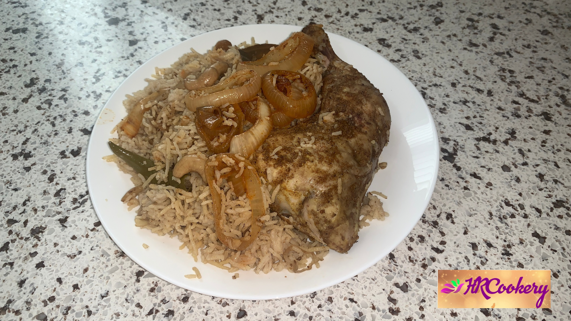 A beautifully garnished plate of chicken mandi, featuring fragrant rice, tender chicken pieces, and fresh herbs, served with a side of tomato sauce.