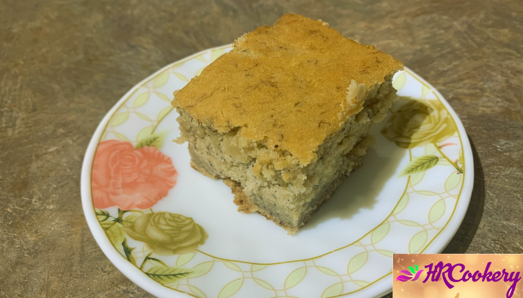 Moist and fluffy homemade banana cake with golden crust on a serving plate, garnished with sliced bananas and walnuts.