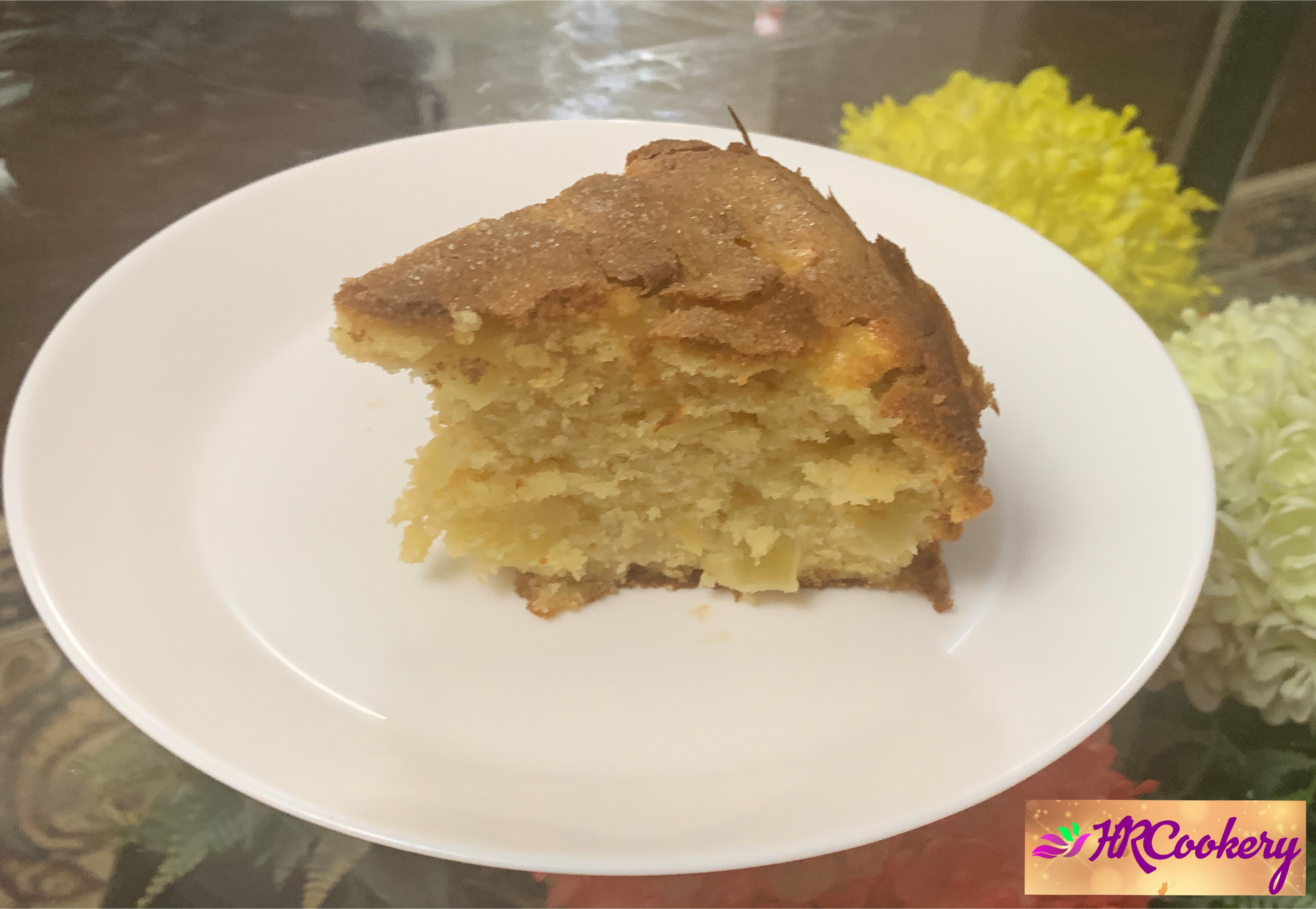 Sliced French Apple Cake on a plate, garnished with apple slices.