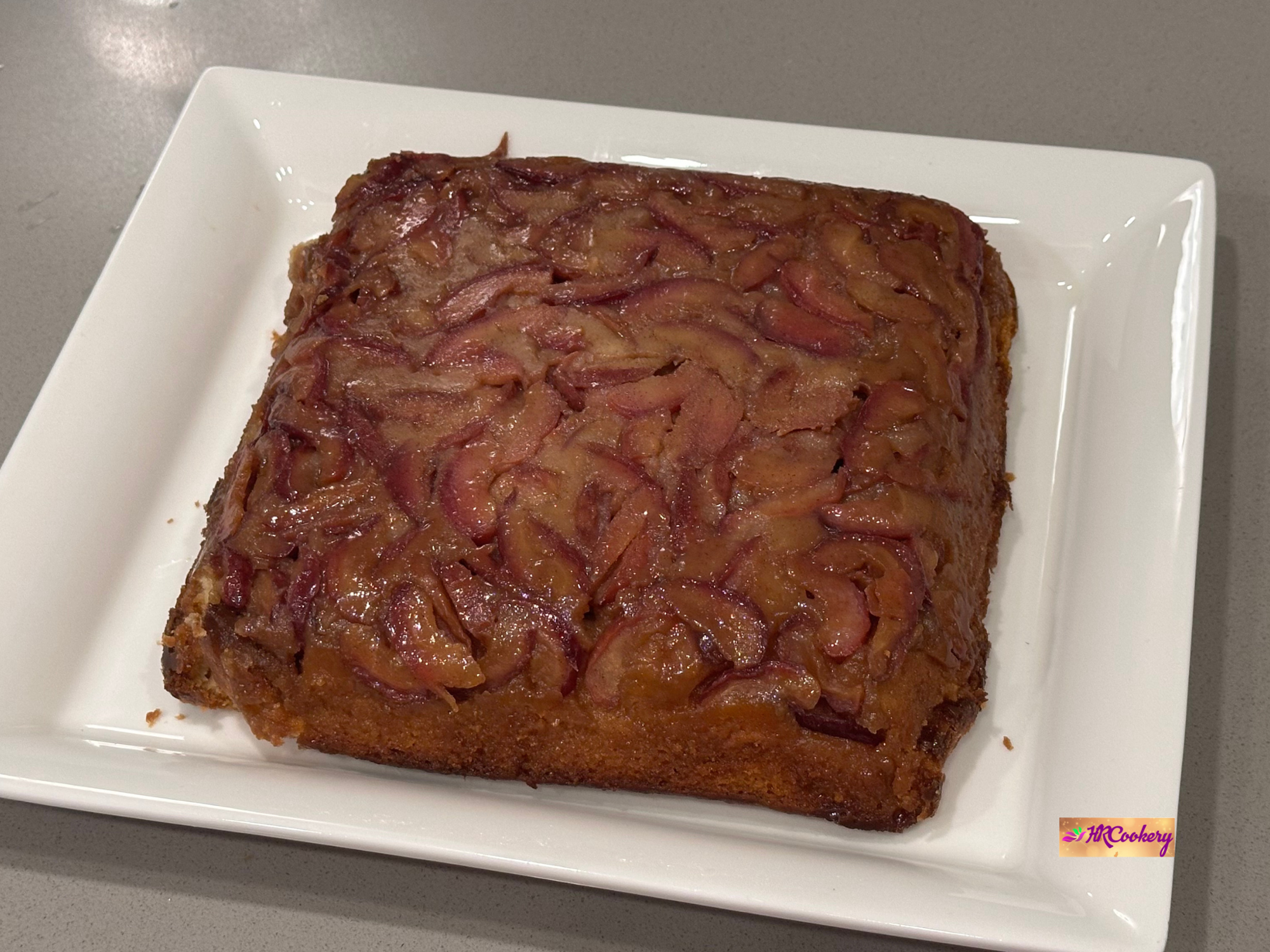 Apple upside-down cake with caramelized apple topping on a white plate