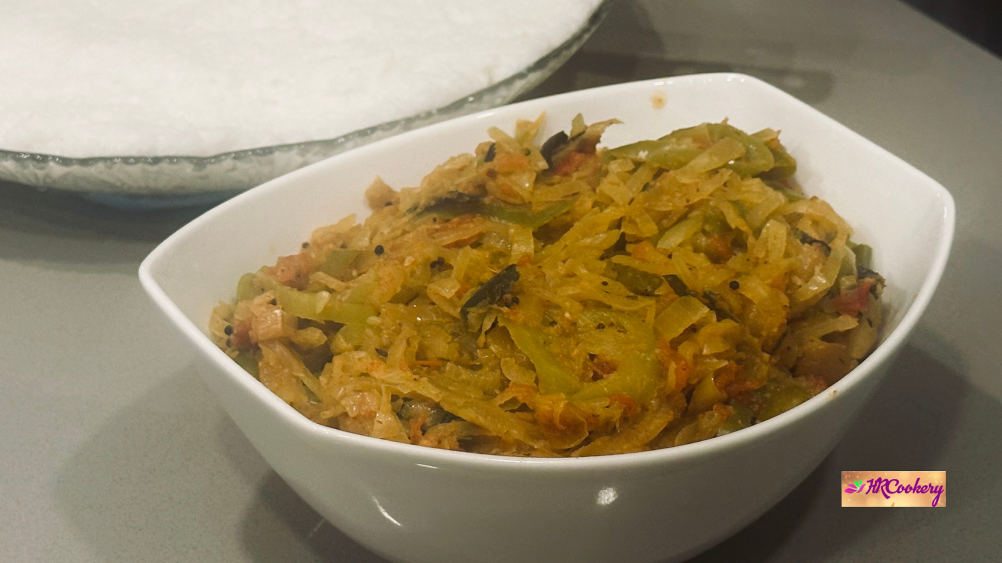 Green banana pepper curry (puli curry) served in a white bowl with a tangy, spicy masala.
