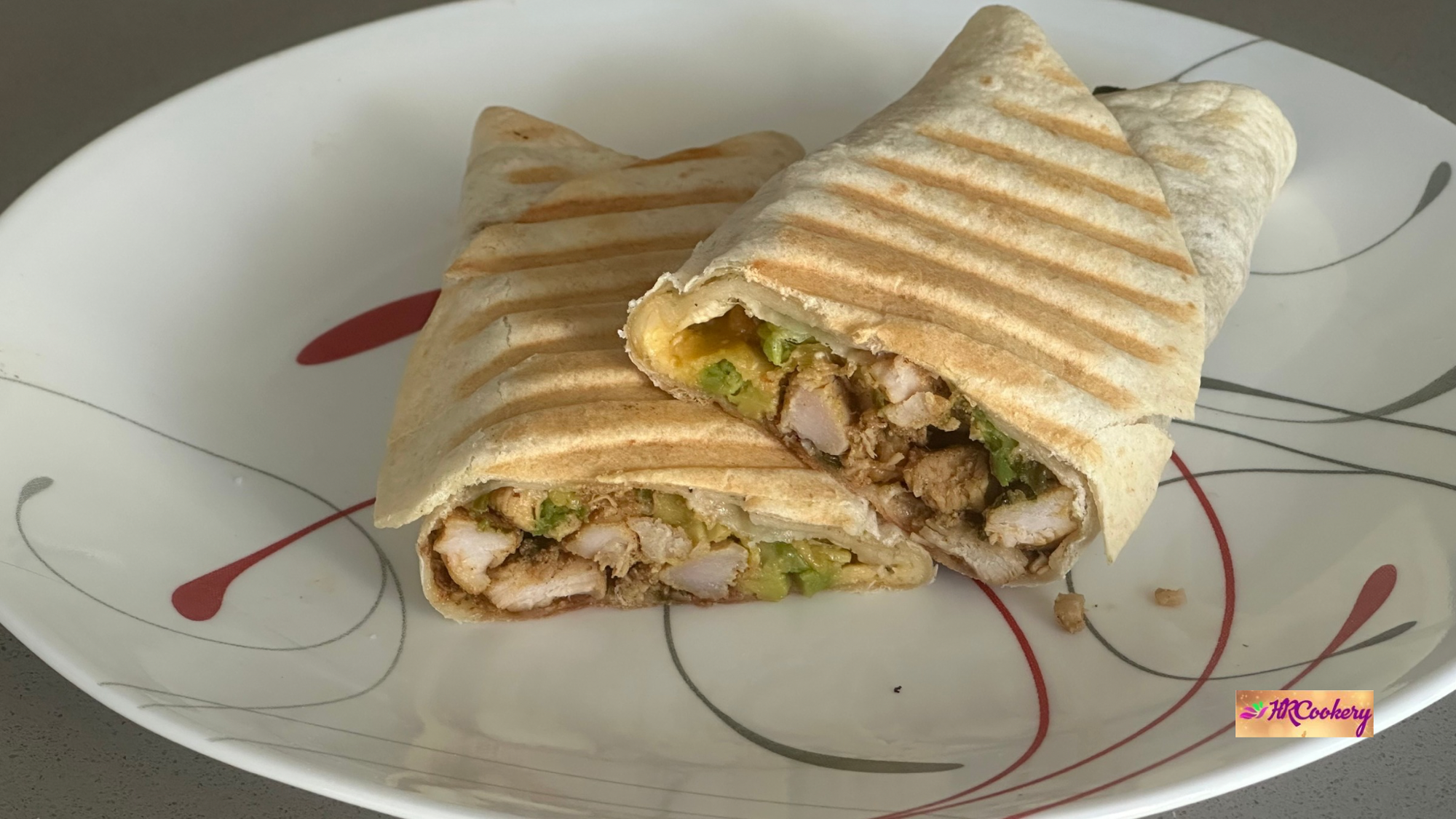Chicken and avocado ranch burritos cut in half, showing juicy chicken, creamy avocado, and grilled tortilla wrap.