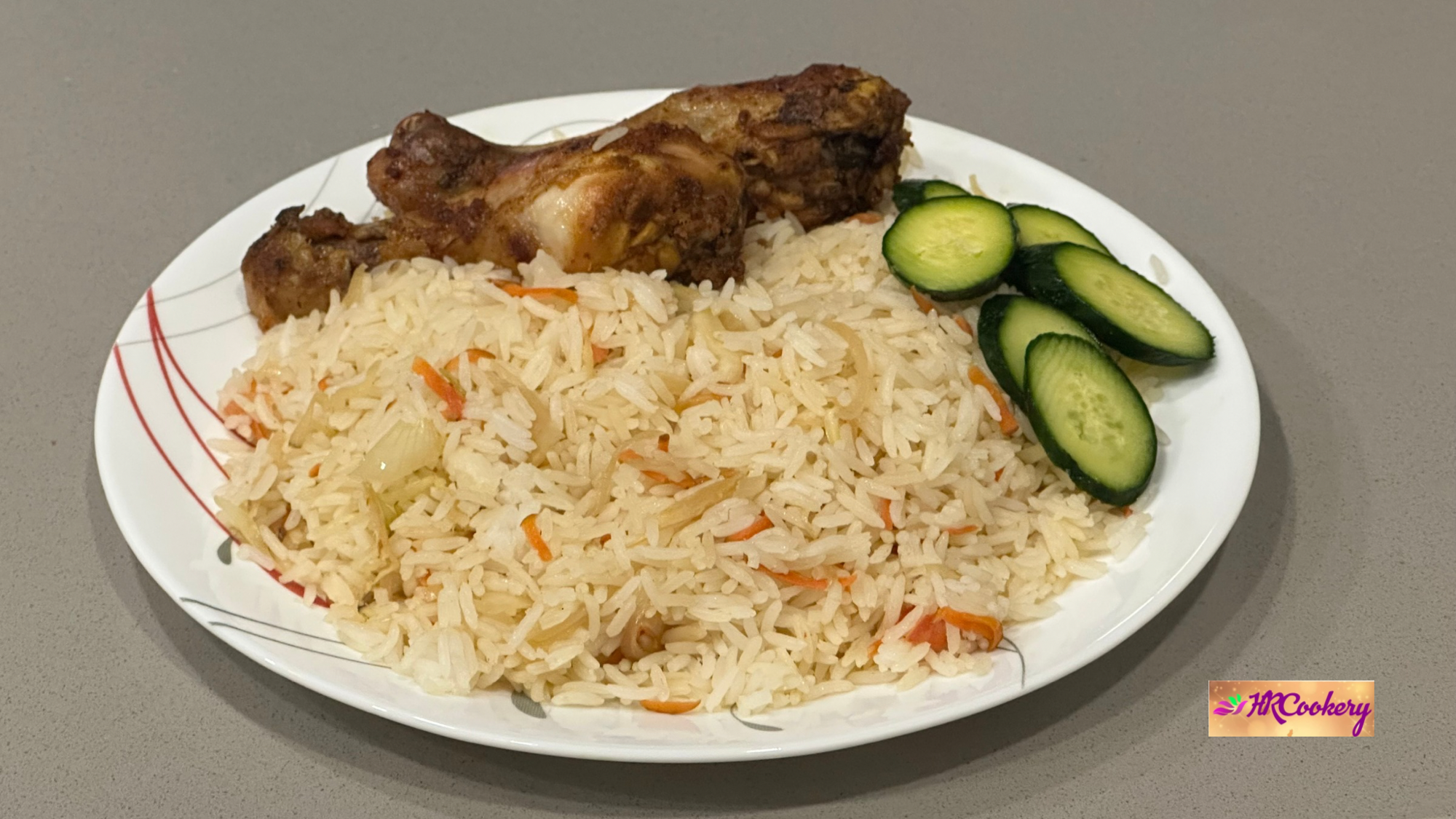 Plate of fragrant ginger rice served with roasted chicken drumsticks and fresh cucumber slices.