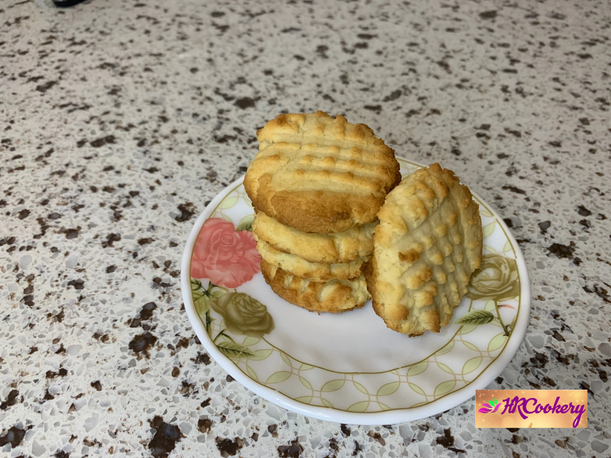 Freshly baked cream cheese cookies on a cooling rack, some sprinkled with powdered sugar.