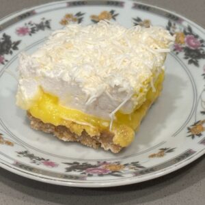 Custard and coconut marshmallow bar layered with creamy custard and coconut topping on a plate