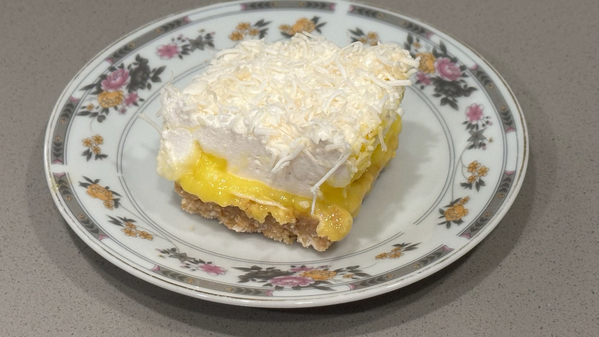Custard and coconut marshmallow bar layered with creamy custard and coconut topping on a plate